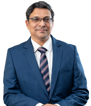 Devendra Phadke, dressed in a suit and tie, stands with hands folded,representing Purnartha Investment Advisers.