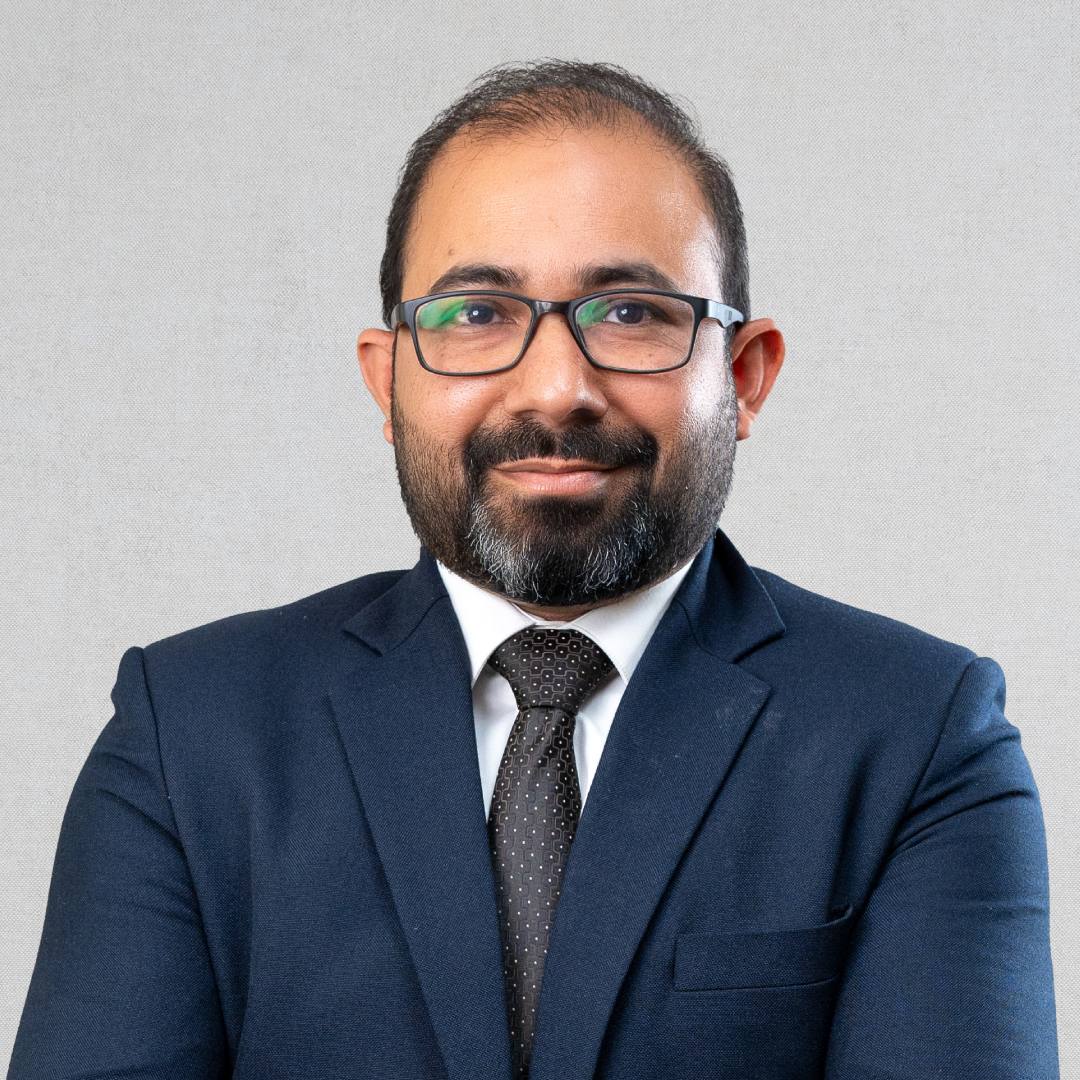A man with glasses and a beard in a suit, head of investment counsellors at Purnartha, overseeing portfolio analysis